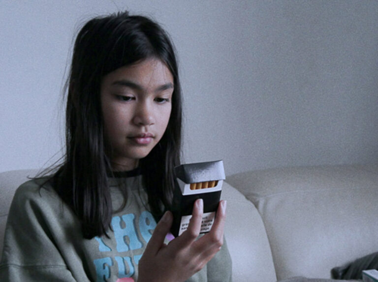 Young girl with packet of cigarettes